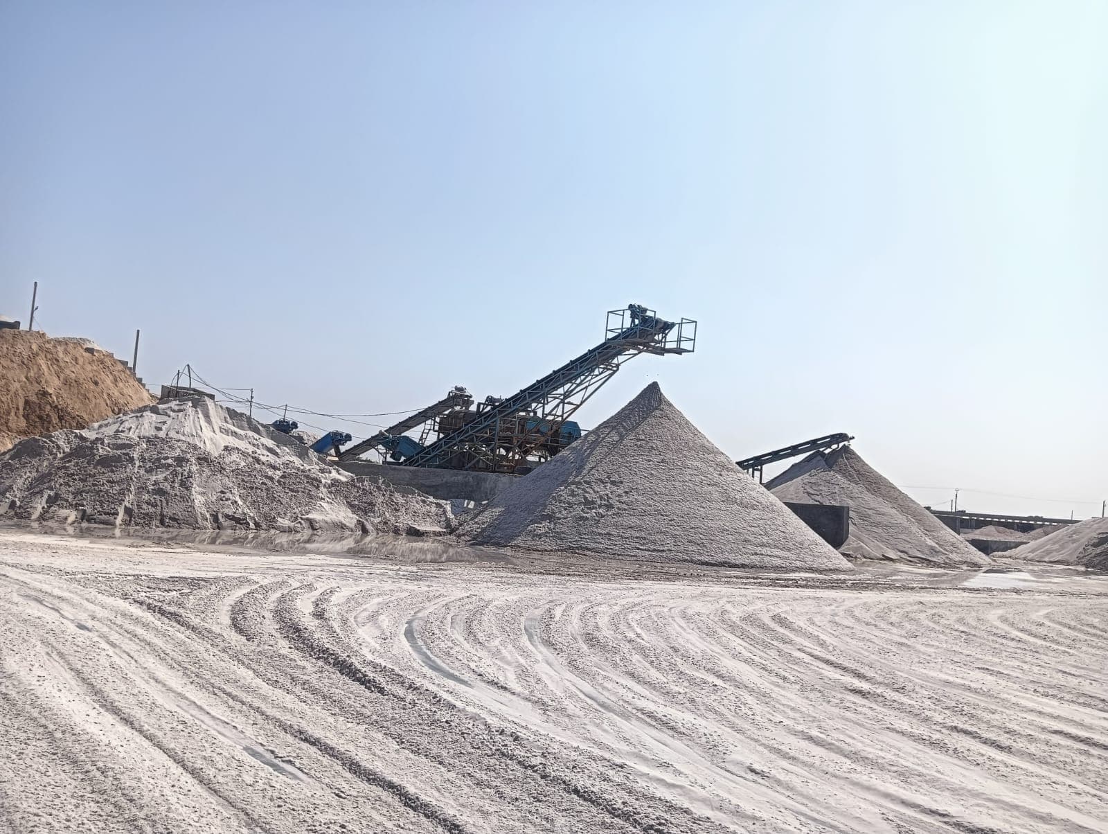 Conveyor belt building conical silica sand stockpiles