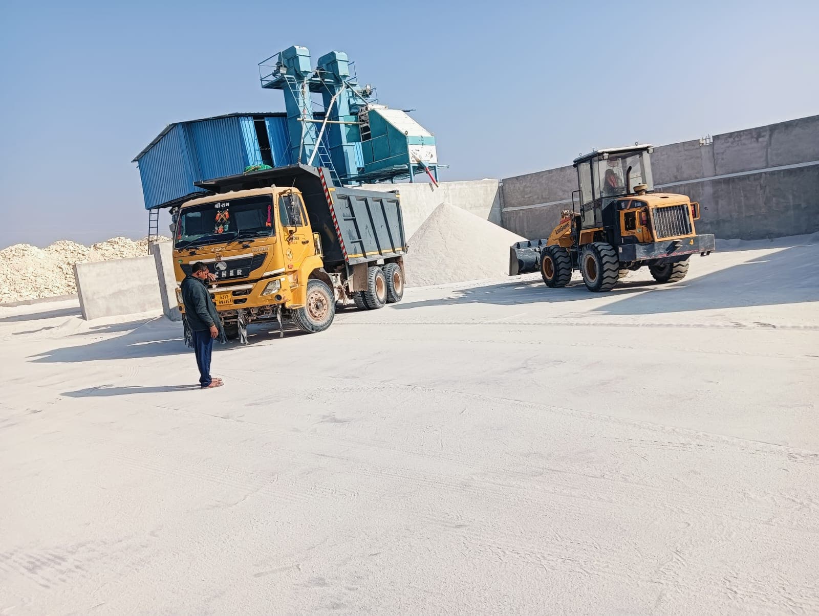 Tipper truck and wheel loader at the blue processing plant